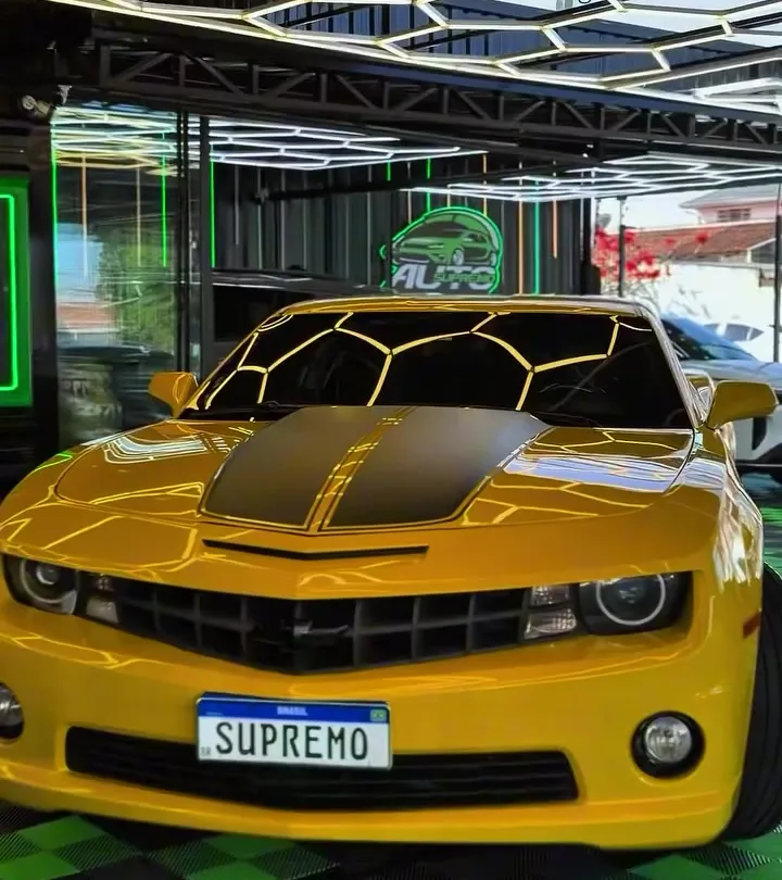 Capô de Camaro refletindo as luzes hexagonais do box