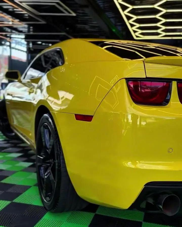 Traseira de Camaro amarelo com lanternas brilhando