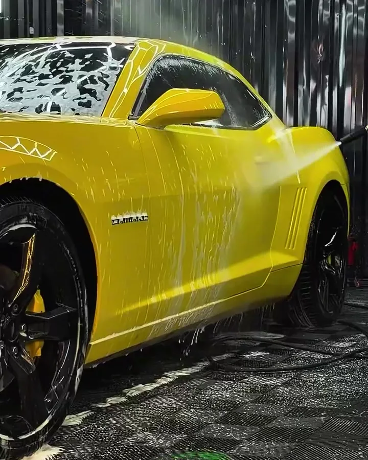 Camaro amarelo coberto de espuma durante lavagem detalhada