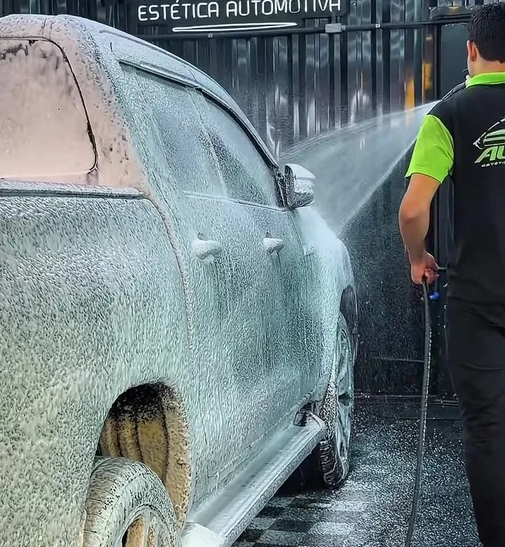 Profissional enxaguando caminhonete com espuma
