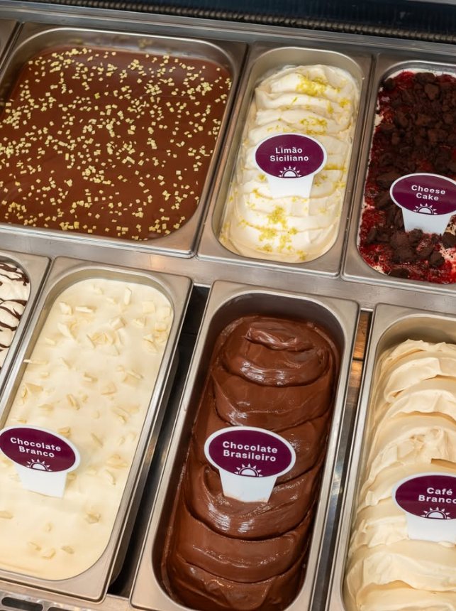 Vitrine de gelatos: Limão Siciliano, Cheese Cake, Chocolate Branco, Chocolate Brasileiro e Café Branco